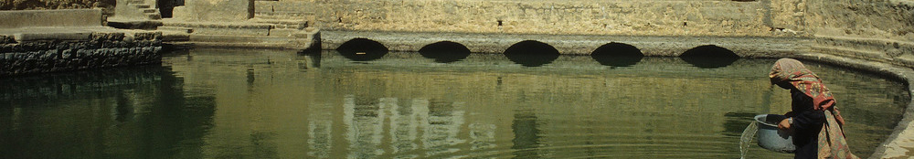 Stille Frau schöoft Wasser aus Zisterne